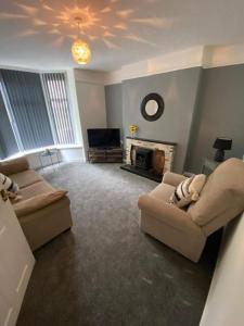 a living room with two couches and a television at Belle Vue in Pontnewynydd