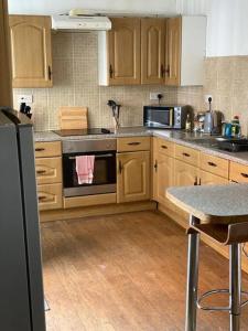 een keuken met houten kasten en een fornuis met oven bij Belle Vue in Pontnewynydd