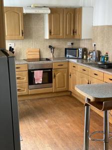 a kitchen with wooden cabinets and a stove top oven at Belle Vue in Pontnewynydd