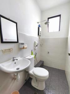 uma casa de banho com um WC branco e um lavatório. em Benoni Garden Apartment Guesthouse em Papar