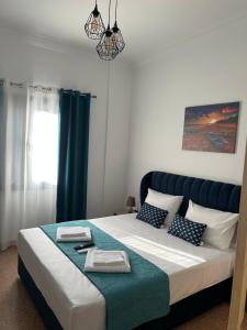 Technopolis Luxury Apartments في أثينا: غرفة نوم بسرير كبير ومخدات زرقاء وبيضاء