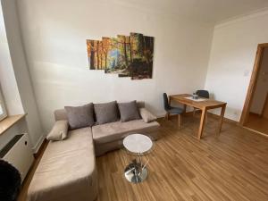 a living room with a couch and a table at Ferienwohnung „Lochbach“ in Bad Mergentheim