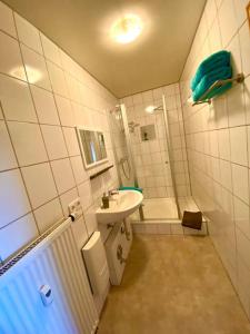 y baño pequeño con lavabo y ducha. en Ferienwohnung „Lochbach“, en Bad Mergentheim
