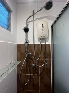 a shower in a bathroom with a shower head at Nilam 3 Cozy Homestay Cyber City 3BR Near KKIA 10 minutes KK Centre wifi 30mps astro channel in Kapayan