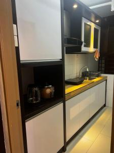 a kitchen with white cabinets and a sink at Cozy Homestay Cyber City 3BR Near KKIA 10 minutes KK Centre wifi 30mps astro channel in Kapayan