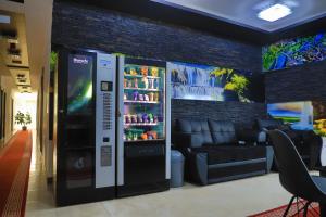 a soda vending machine in a room with a couch at Konak kod Hame in Bihać