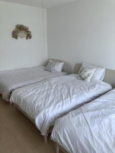 dos camas sentadas una al lado de la otra en una habitación en Nakijin Resort Guest House, en Nakijin