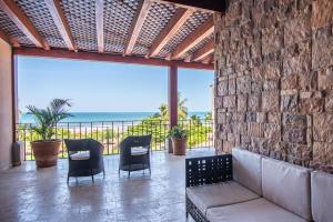 een woonkamer met een bank en stoelen en de oceaan bij Crocs Resort & Casino in Jacó