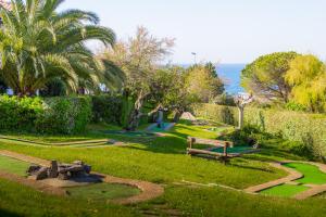 un parc avec un banc, des arbres et l'océan dans l'établissement Village Vacances Azureva Anglet, à Anglet