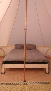 a bed with a canopy in a tent at Cosy Farmhouse Glamping in Stege
