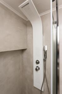 a shower with a shower head in a bathroom at City Vibes Apartment in Thessaloniki