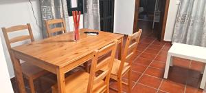een houten tafel met stoelen en een vaas erop bij Apartamento EXCLUSIVE TRIANA - Ribera del Guadalquivir in Sevilla