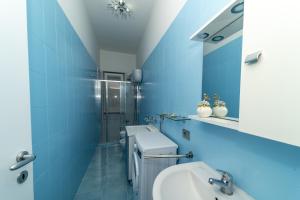 een blauwe badkamer met een wastafel en een spiegel bij John House in Sorrento