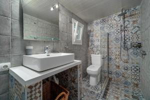 a bathroom with a sink and a toilet and a shower at Amouage Boutique Home in Skiathos