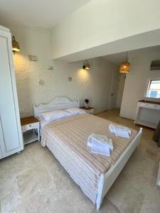een slaapkamer met een groot bed en 2 handdoeken bij Serez Otel Alaçatı by La Mira in Ildır