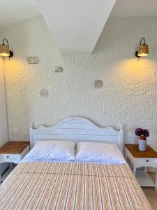 een slaapkamer met een wit bed met 2 tafels en 2 verlichting bij Serez Otel Alaçatı by La Mira in Ildır