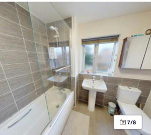 a bathroom with a toilet and a sink and a bath tub at Dengenzy House in Seacroft