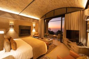 a bedroom with a large bed and a television at Angels View Hotel in Graskop