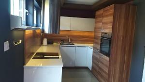 a small kitchen with a sink and a stove at Dom Apart Magda Rewal in Rewal
