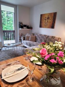 a living room with a table with a vase of flowers at Winterberg Appartement 21056 in Winterberg