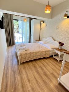 een slaapkamer met een bed en een houten vloer bij Serez Otel Alaçatı by La Mira in Ildır