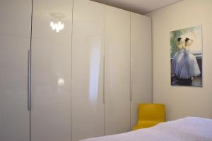 a bedroom with a white wardrobe and a yellow chair at Seebach Wohnung 06 in Boltenhagen