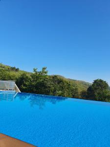 einem blauen Pool mit einem Stuhl vor einem Hügel in der Unterkunft Quinta de Cerdeiró in Mões