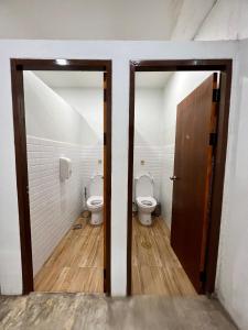 a bathroom with two toilets and a wooden door at Together Backpackers Hostel in Chiang Rai