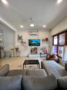 a living room with a couch and a tv at Together Backpackers Hostel in Chiang Rai