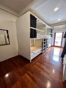 a room with bunk beds and a wooden floor at Together Backpackers Hostel in Chiang Rai
