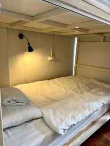 a large white bed in a room with a lamp at Together Backpackers Hostel in Chiang Rai