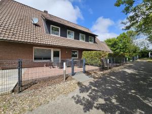 a house with a fence in front of it at Mienhus Apartments Ferienwohnung Famke in Norden