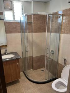 a bathroom with a shower with a toilet and a sink at Palladium Luxury Suites Financial District Unit I in Hyderabad