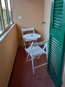 un tavolo e sedie in una piccola stanza con finestra di Affittacamere L'Arco a Volastra