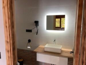 ein Badezimmer mit einem weißen Waschbecken und einem Spiegel in der Unterkunft FUENTE OSCURA in Ramales de la Victoria