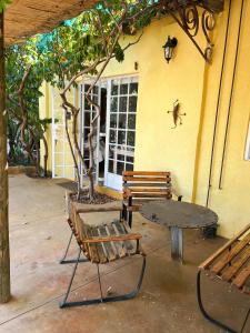 einen Tisch, zwei Bänke, einen Tisch und einen Baum in der Unterkunft Eins Art Studios in Omaruru