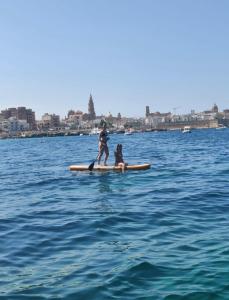 two people on a paddle board in the water at boat and breakfast in Bari