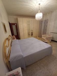 a bedroom with a large white bed with a chandelier at Affittacamere L'Arco in Volastra