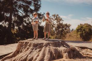 two young boys standing on top of a tree stump at La Résidence du Bailli in Rayol-Canadel-sur-Mer