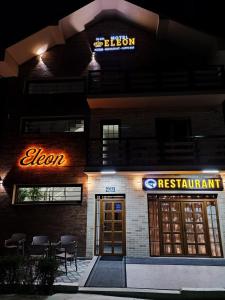a hotel exterior at night with a sign for a restaurant at Eleon Motel in Brezovicë