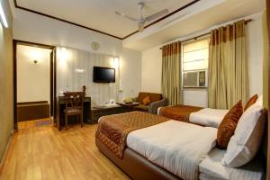 Habitación de hotel con 2 camas y sala de estar. en The Solace, en Nueva Delhi