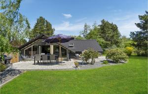 Cette maison dispose d'une terrasse avec un parasol. dans l'établissement Stunning Home In Rdby With Kitchen, à Rødby
