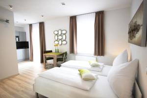 a hotel room with two beds and a table at Aparthotel Gartenstadt in Bamberg
