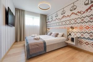 a bedroom with a bed and a tv on a wall at Apartamenty Pod Gondolą - Mountain Resort Villa - Dream Apart in Szczyrk