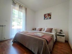 a bedroom with a large bed and a window at Apartment Vetva in Nedeščina +32 photos
