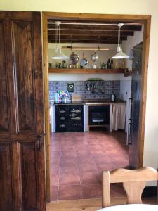 een keuken met een houten deur en een tegelvloer bij Casa Tula in Ortigueira