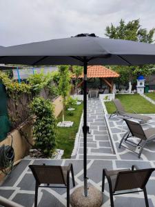 czarny parasol na patio z krzesłami w obiekcie Villa Gallen w mieście Limenas