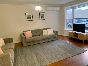 a living room with a couch and a television at Location, Location, Location! Walk to beach & town in Mornington