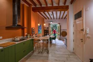 una cocina con armarios verdes y una mesa con taburetes en Casa Carmen Murcia, en Murcia