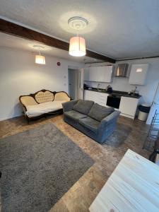 a living room with a couch and a kitchen at Tegfan -The Anglesey Townhouse in Caernarfon